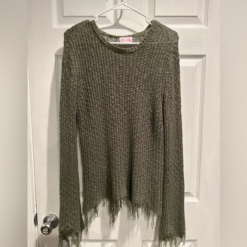 Army green light sweater with fringe styling on sleeves and bottoms.
